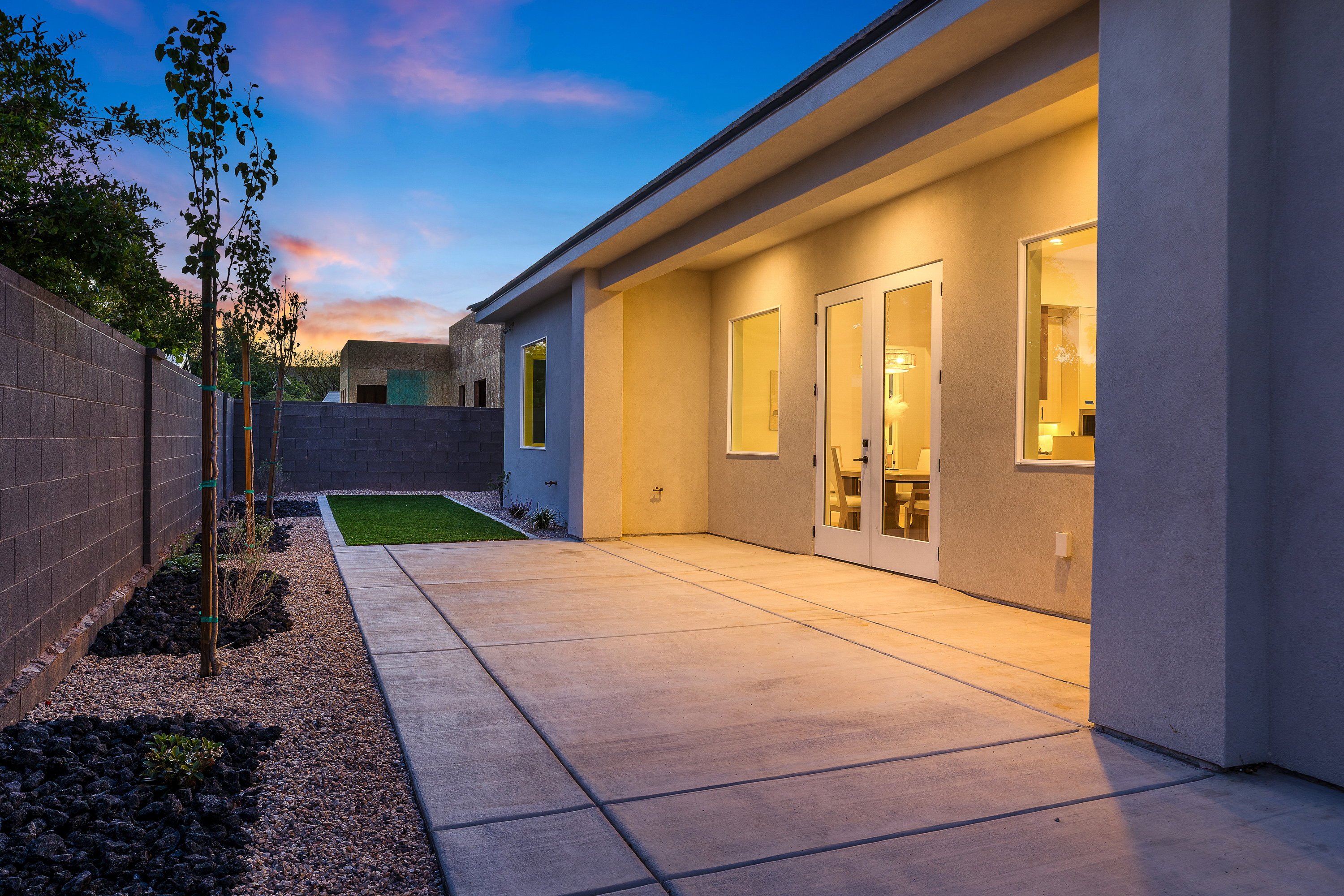 Patio terrace at dusk featuring a fenced backyard, a patio area, and french doors