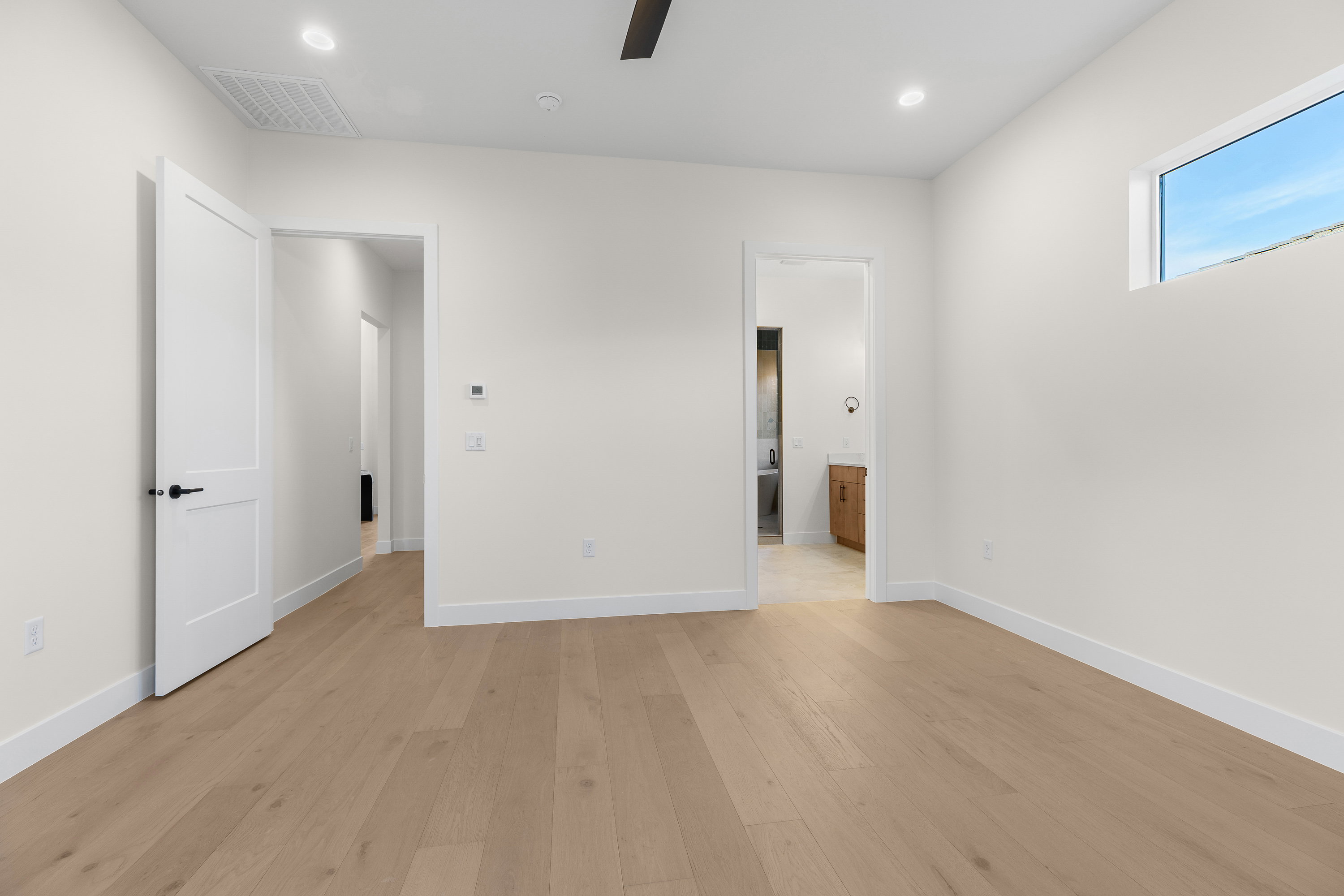 Unfurnished bedroom with light wood finished floors, ensuite bath, ceiling fan, and recessed lighting