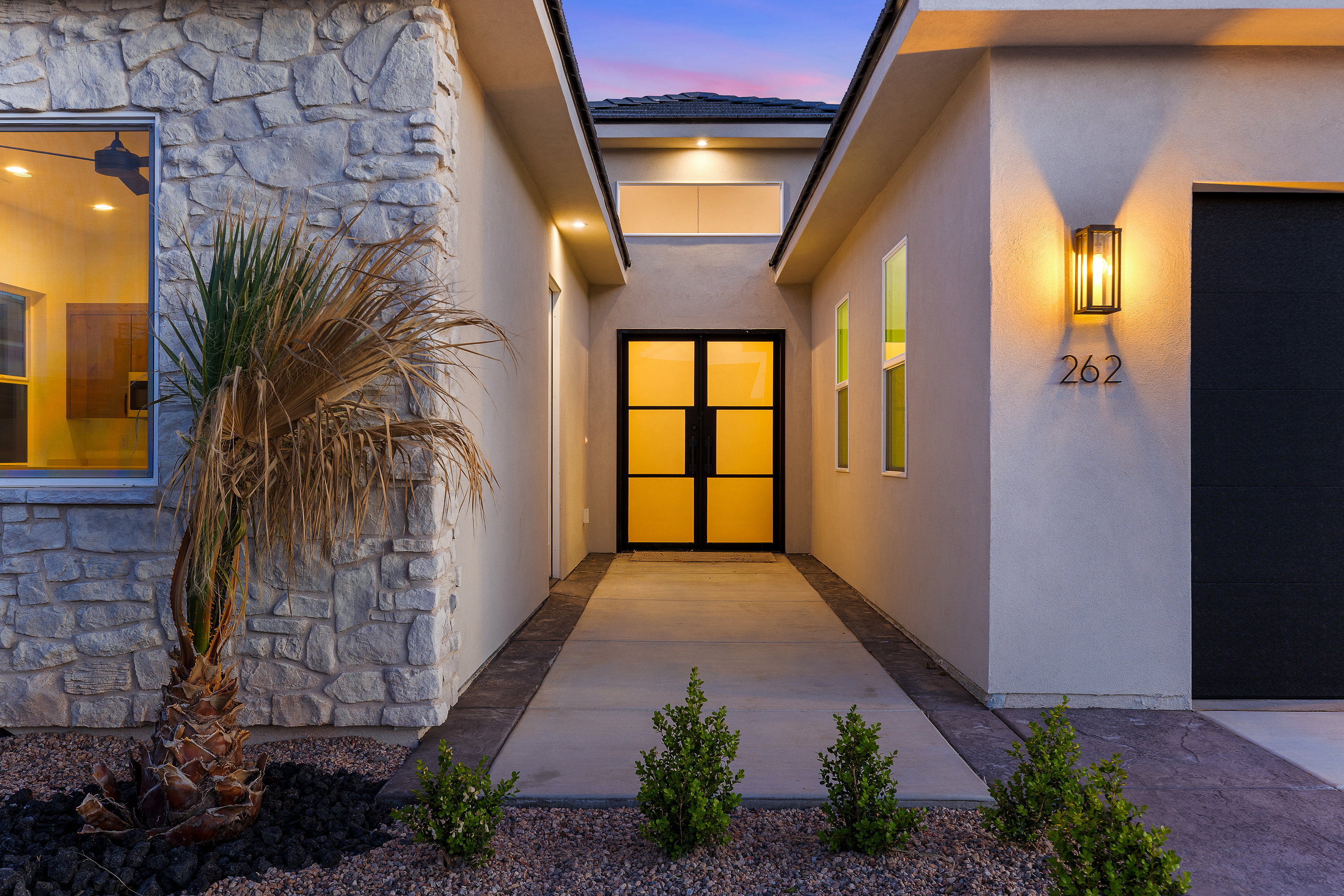 Entrance to property with stone siding and stucco siding