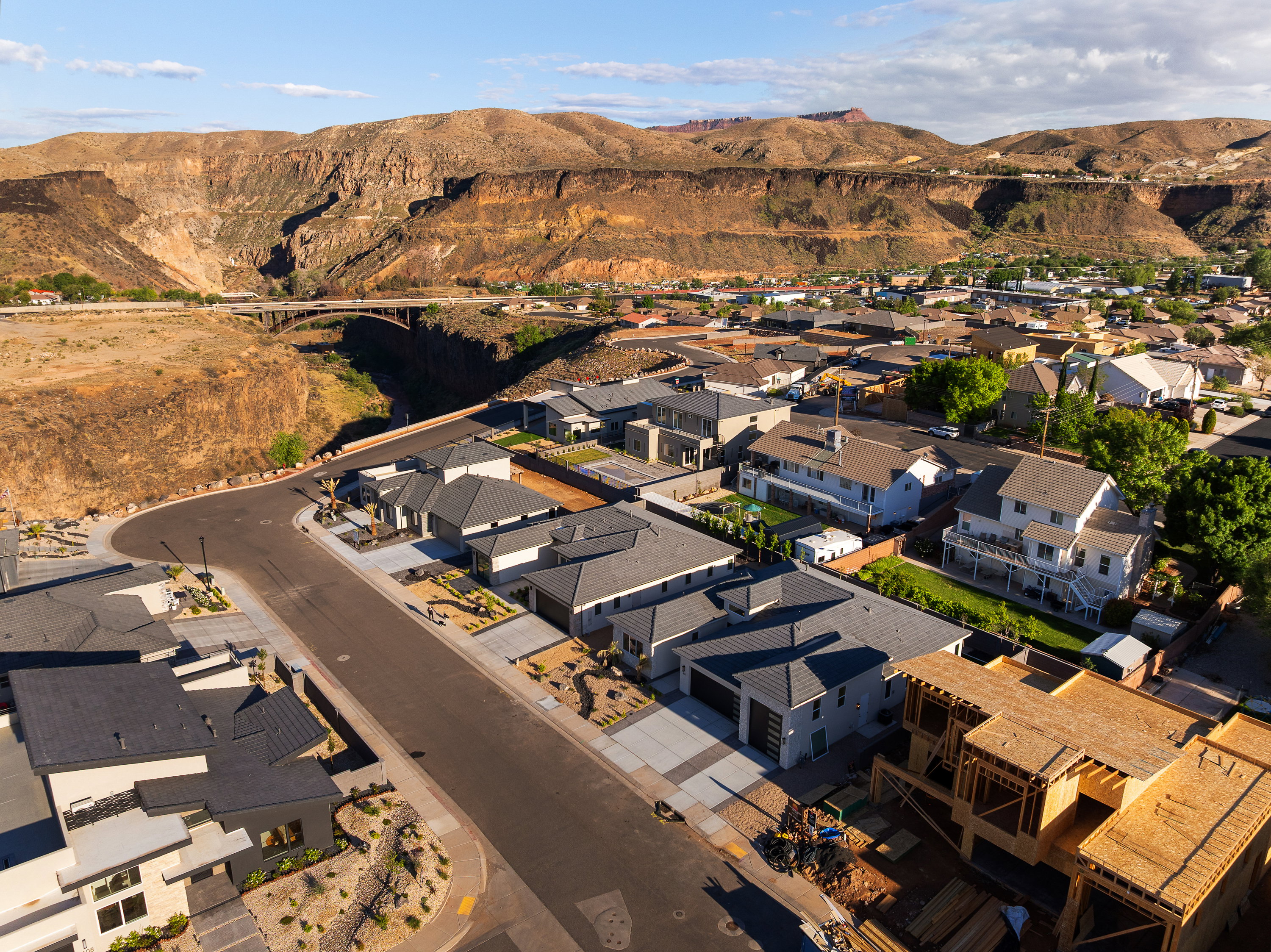 Aerial view of property and surrounding area featuring a mountain backdrop and nearby suburban area
