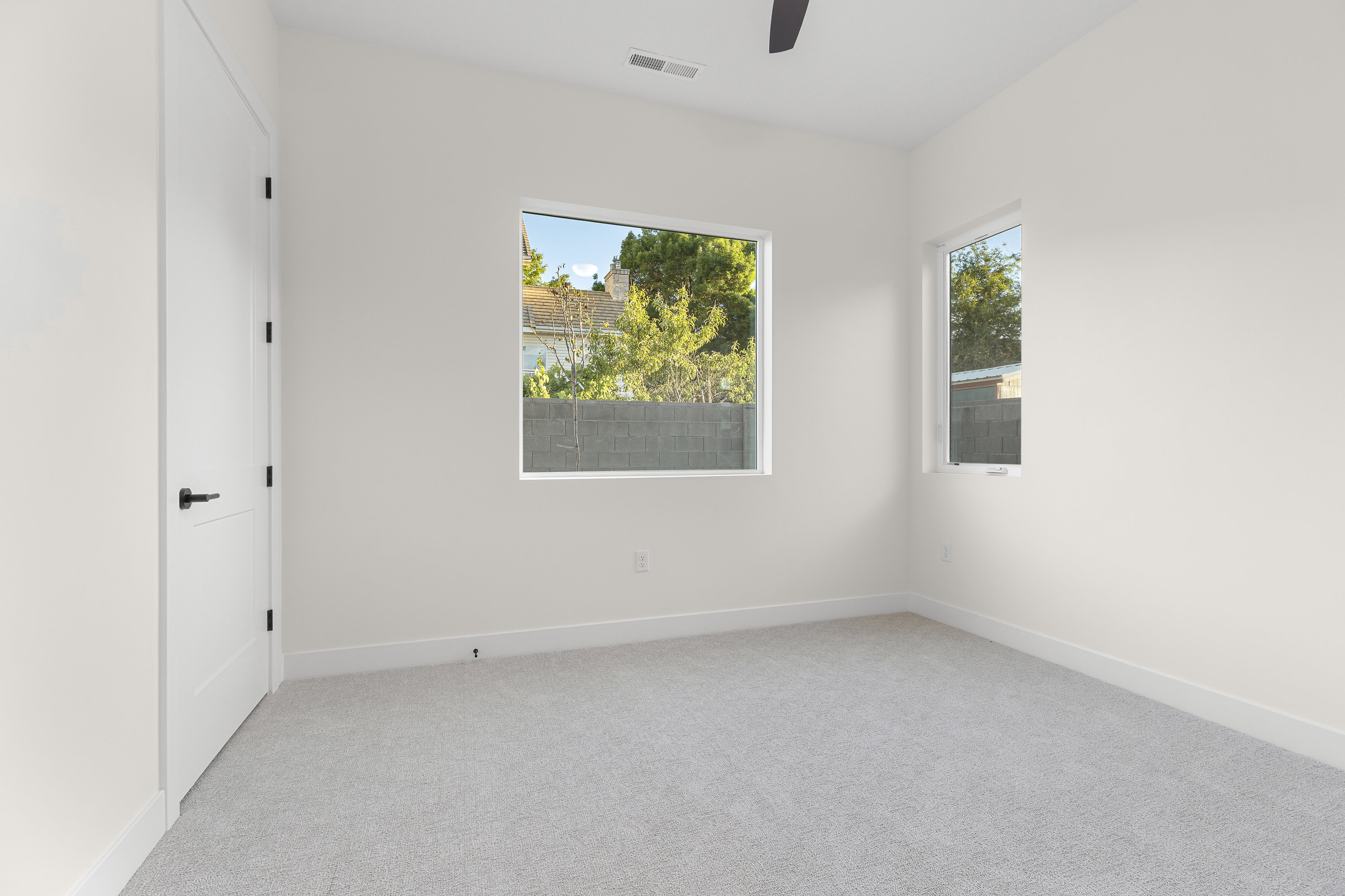 Unfurnished room featuring light colored carpet, healthy amount of natural light, and a ceiling fan