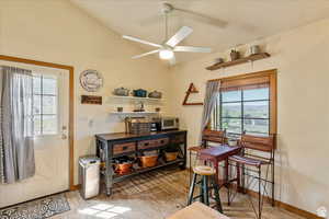 Dining space with lofted ceiling, a ceiling fan, and light wood-type flooring