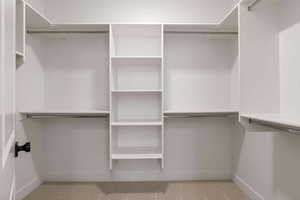 Walk in closet with light carpet