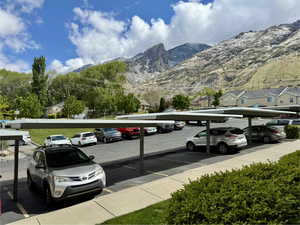 Partially covered parking lot featuring a mountain view and a residential view