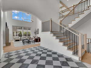 Foyer with suspended lighting, a high ceiling, and arched walkways