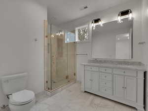 Full bathroom featuring double vanity, a stall shower, and light marble finish floors