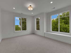 Empty room featuring light carpet, recessed lighting, and plenty of natural light