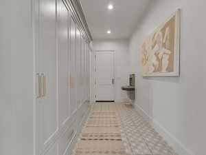 Corridor with baseboards and recessed lighting