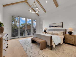 Bedroom featuring light wood-style floors, access to outside, lofted ceiling, and suspended lighting