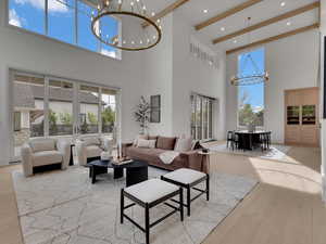 Living area featuring a chandelier, light wood-style floors, and plenty of natural light