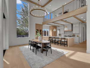 Dining area with light wood-style flooring and suspended lighting