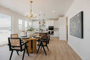 Dining room with light wood-style flooring and a chandelier
