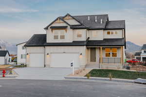 Modern farmhouse with a mountain view, roof with shingles, covered porch, and driveway