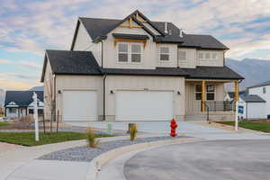 Modern farmhouse with board and batten siding, a shingled roof, and a porch