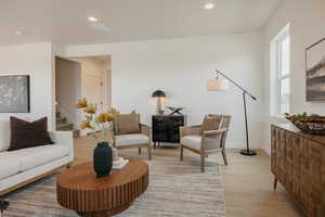 Living area with light wood-style floors and recessed lighting
