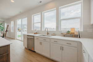Kitchen featuring light wood-style floors, dishwasher, recessed lighting, white cabinetry, and a mountain view