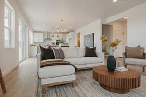 Living area with a chandelier and light wood-style floors