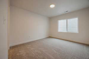 Spare room with light colored carpet and baseboards
