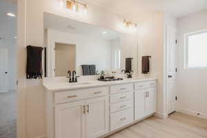 Bathroom with double vanity, light wood-style floors, and recessed lighting