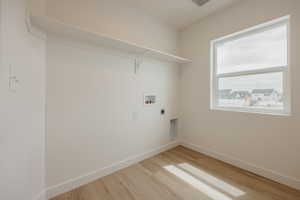 Laundry room with light wood-style flooring, hookup for a washing machine, and electric dryer hookup