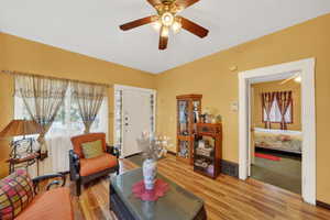 Living area with light wood-style floors and ceiling fan