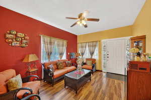 Living room featuring wood finished floors, plenty of natural light, and a ceiling fan