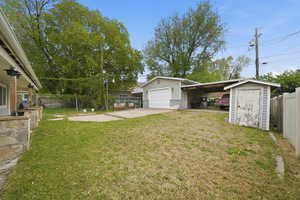 View of yard featuring driveway and a shed