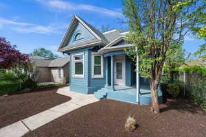 Victorian house featuring a shingled roof and covered porch