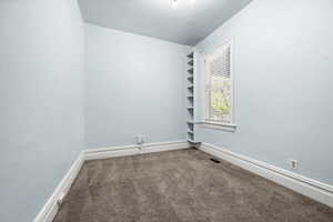 Unfurnished room featuring carpet and baseboards