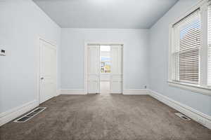 Empty room with dark carpet and baseboards
