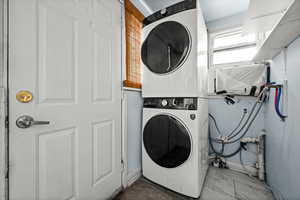 Laundry room with stacked washer and clothes dryer