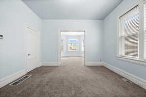 Empty room featuring carpet and baseboards