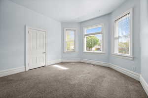 Carpeted empty room featuring baseboards
