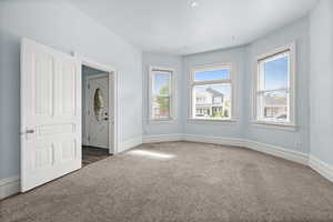 Spare room featuring carpet flooring and baseboards