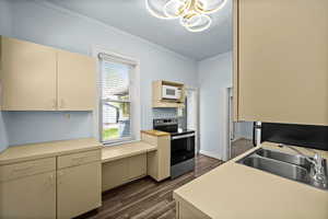 Kitchen featuring stainless steel range with electric cooktop, dark wood finished floors, light countertops, and crown molding