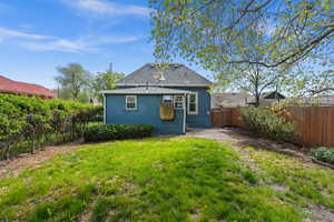 Rear view of property featuring a fenced backyard, a patio, a gate, and roof with shingles