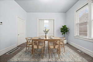 Carpeted dining room featuring baseboards