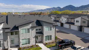 View of front of home featuring board and batten siding, a residential view, stone siding, and a mountain view