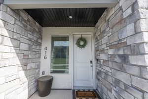 Entrance to property featuring stone siding