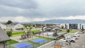 View of tennis court featuring a mountain view, a community pool, and a residential view