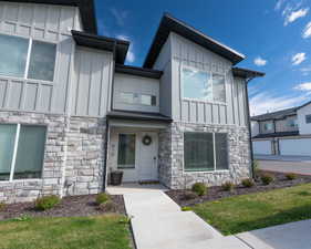 View of front of home featuring stone siding, board and batten siding, and a front yard