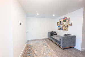 Living area featuring light carpet and recessed lighting