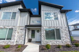 View of front of house featuring board and batten siding and stone siding