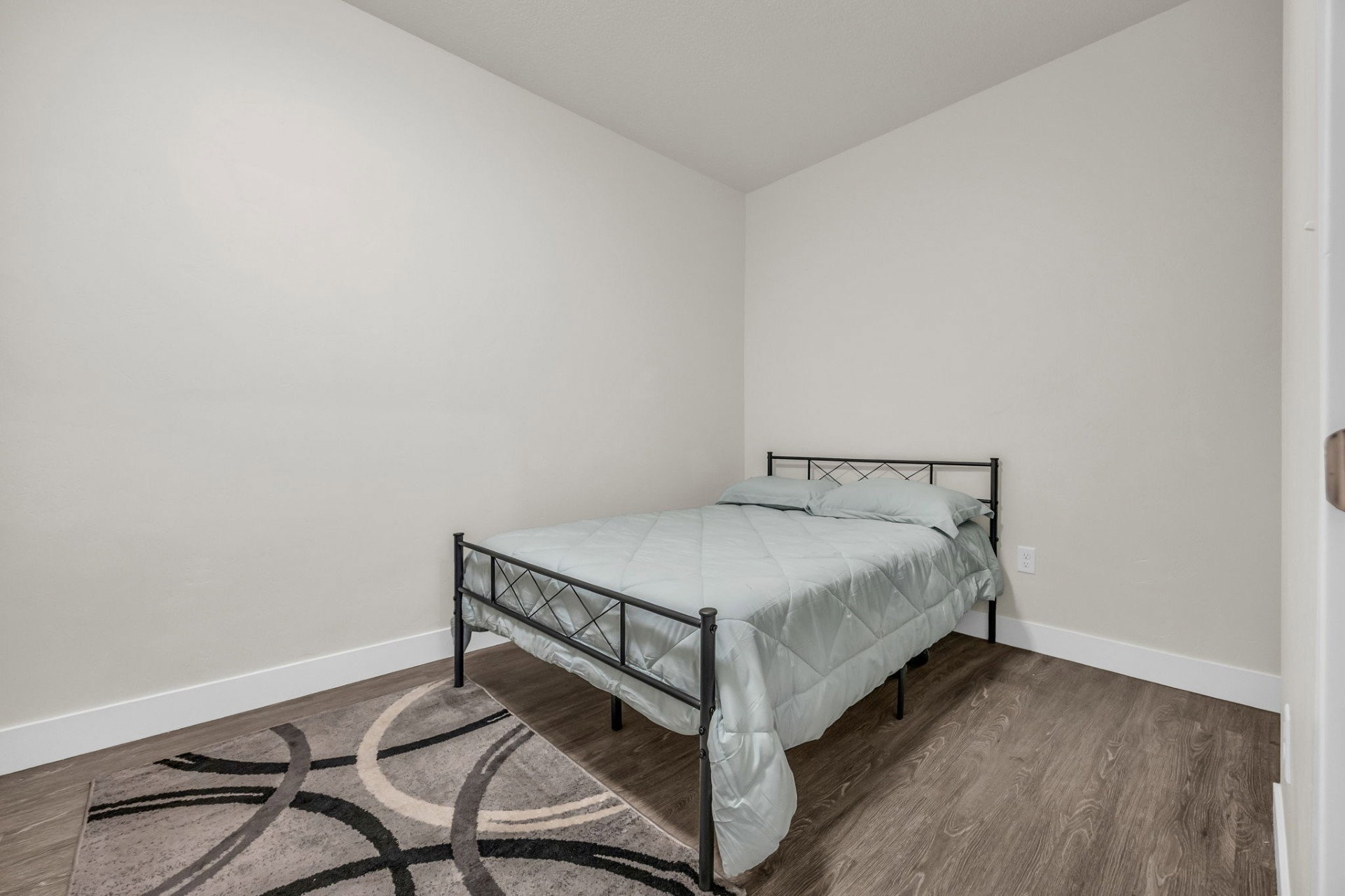 Bedroom featuring dark wood finished floors and baseboards