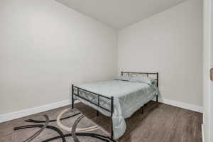 Bedroom featuring dark wood finished floors and baseboards
