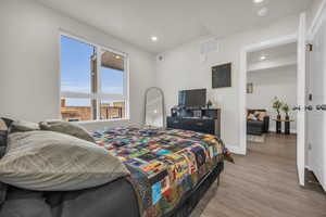Bedroom with wood finished floors and recessed lighting