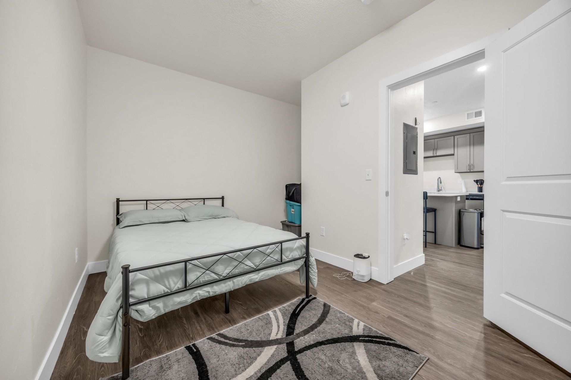 Bedroom with dark wood-style floors and electric panel