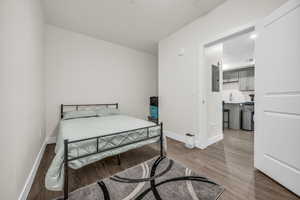 Bedroom with dark wood-style floors and electric panel