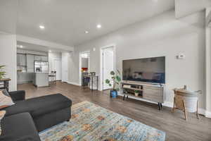 Living room with recessed lighting and dark wood-style floors