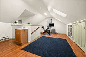 Workout room with light wood-style flooring and a skylight